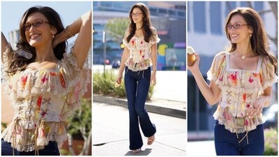 Bella Hadid's latest look channels Y2K fashion with a modern twist. She rocked a frill top adorned with a white floral pattern and corset tightening, paired with bootcut jeans, transparent glasses and chunky jewels, exuding pure sassiness. (Instagram/@justjared) Bella Hadid's latest look channels Y2K fashion with a modern twist. She rocked a frill top adorned with a white floral pattern and corset tightening, paired with bootcut jeans, transparent glasses and chunky jewels, exuding pure sassiness. (Instagram/@justjared)