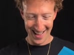 The image shows Mark Zuckerberg holding a gold chain he received as a gift from T-Pain. 