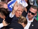 Republican presidential candidate and former U.S. President Donald Trump gestures with a bloodied face while he is assisted by U.S. Secret Service personnel after he was shot in the right ear during a campaign rally at the Butler Farm Show in Butler, Pennsylvania, U.S., July 13, 2024. REUTERS/Brendan McDermid/File Photo