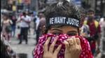 A student covers her face after security personnel fired tear gas shells to disperse protesters in Kolkata on Tuesday. (PTI Photo)