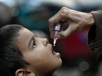 A health worker administers a polio vaccine to a child in Karachi, Pakistan. 