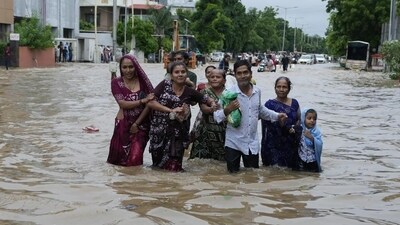 A family wades through a waterlogged road after heavy rainfall in Ahmedabad, Gujarat, on Wednesday. Intense monsoon rains and flooding have hit Gujarat, killing at least 28 people in the last three days, according to government officials. (AP) A family wades through a waterlogged road after heavy rainfall in Ahmedabad, Gujarat, on Wednesday. Intense monsoon rains and flooding have hit Gujarat, killing at least 28 people in the last three days, according to government officials. (AP)