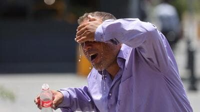An Iranian taxi driver splashes water on himself to cool down during the heat surge in Tehran, Iran, on July 21. (REUTERS) An Iranian taxi driver splashes water on himself to cool down during the heat surge in Tehran, Iran, on July 21. (REUTERS)