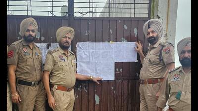 Cops paste a notice on one of the properties of ‘smuggler’ Happy Jatt in Pilibhit, Uttar Pradesh.