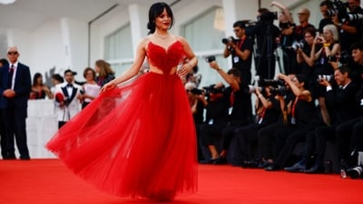 Beetlejuice Beetlejuice cast member Jenna Ortega poses on the red carpet during the film's screening at the 81st Venice Film Festival. She wore a custom Dior gown inspired by Winona's character Lydia's wedding dress from the original movie. She wore the tulle red dress featuring side cut-outs, a backless design, and spaghetti straps. A choker necklace, rings, bracelets, a messy hairdo, smoky red eyes, and bold red lips completed the look.&nbsp; (REUTERS)