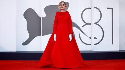 The 81st Venice Film Festival Jury president Isabelle Huppert posed on the red carpet in Balenciaga couture. The floor-length gown features a large bow on the back, an A-line silhouette, a cascading train on the back, and full-length sleeves. She styled the dress with white gloves, striking jewels, and minimal makeup.&nbsp; (REUTERS)