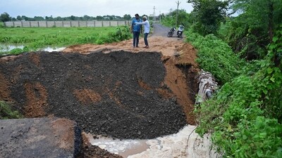 Onlookers examine a road damaged by heavy rains on the outskirts of Ahmedabad on Wednesday. (AFP) Onlookers examine a road damaged by heavy rains on the outskirts of Ahmedabad on Wednesday. (AFP)