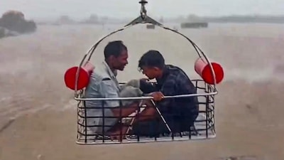 Two people are rescued by an Indian Coast Guard aircraft from a flood-affected area following heavy rainfall in Devbhumi Dwarka district, Gujarat, on Thursday. (PTI) Two people are rescued by an Indian Coast Guard aircraft from a flood-affected area following heavy rainfall in Devbhumi Dwarka district, Gujarat, on Thursday. (PTI)