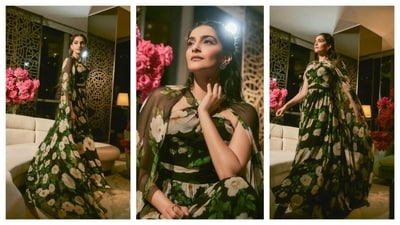 Sonam Kapoor embraced a floral vibe as she donned a billowy and flowy dress. Her black gown had bold beige flowers and green leaves prints all over. It also had a cape, which imparted a more ethereal and romantic vibe to the overall whimsical aesthetic of her ensemble. Her hair was styled in soft waves and she accessorised with a small bag. (Instagram/@rheakapoor) Sonam Kapoor embraced a floral vibe as she donned a billowy and flowy dress. Her black gown had bold beige flowers and green leaves prints all over. It also had a cape, which imparted a more ethereal and romantic vibe to the overall whimsical aesthetic of her ensemble. Her hair was styled in soft waves and she accessorised with a small bag. (Instagram/@rheakapoor)