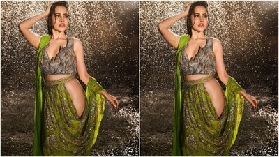 The first look, designed by Abu Jani Sandeep Khosla, shows Uorfi in a 'Hipster' saree 'representing an unconventional sense of style that is also unabashedly dramatic'. The sequinned green saree features a side cut-out revealing Uorfi's hip, and a pallu pleated neatly on the shoulder. She styled the drape with a statement blouse, a side-parted wet-hair look, pink lips, bold kohl-lined eyes, darkened brows, and rouge-tinted cheeks. (Instagram)