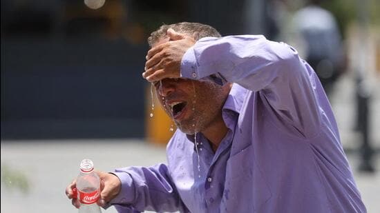 An Iranian taxi driver splashes water on himself to cool down during the heat surge in Tehran, Iran, on July 21. (REUTERS)