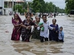 A family wades through a flooded road following heavy rainfall in Ahmedabad, Gujarat. (AP Photo)