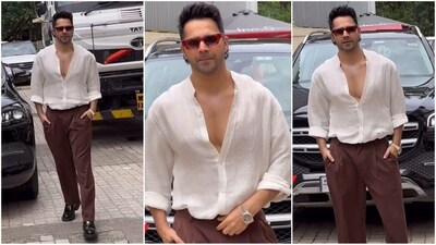 Varun Dhawan looks effortlessly stylish in his latest look, featuring a chic white open-buttoned shirt paired with brown pants. He completes the ensemble with shiny black shoes, a wristwatch and red-rimmed sunglasses. (Instagram) Varun Dhawan looks effortlessly stylish in his latest look, featuring a chic white open-buttoned shirt paired with brown pants. He completes the ensemble with shiny black shoes, a wristwatch and red-rimmed sunglasses. (Instagram)