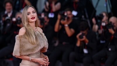 Angelina completed the look with a gold rose brooch and bold red lips. (PTI) Angelina completed the look with a gold rose brooch and bold red lips. (PTI)