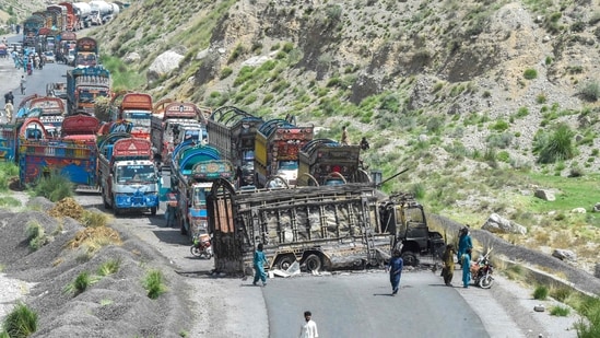 TOPSHOT - People look at a charred vehicle near a collapsed railway bridge a day after a blast by separatist militants at Kolpur in Bolan district, Balochistan province on August 27, 2024. (Photo by Banaras KHAN / AFP) (AFP)