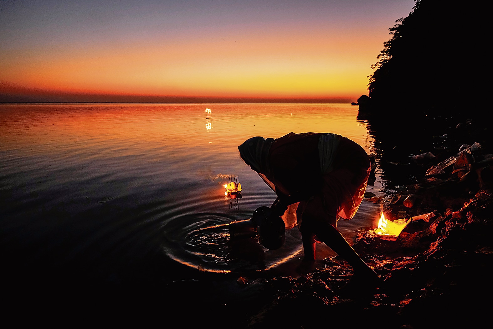 A devotee with diyas on the banks of the Brahmaputra at Diwali. (Adobe Stock) A devotee with diyas on the banks of the Brahmaputra at Diwali. (Adobe Stock)