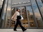 A woman, using a portable fan during hot summer day, walks past a Balenciaga store at Ginza shopping district in Tokyo, Japan, August 11, 2024. REUTERS/Willy Kurniawan