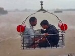 Two people being rescued by an Indian Coast Guard aircraft from a flood-hit area following heavy rainfall, at Devbhumi Dwarka district of Gujarat.