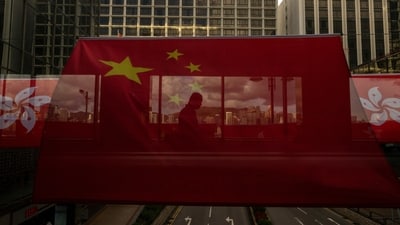 FILE- A pedestrian walks through a footbridge is silhouetted as Chinese and Hong Kong flags are strung to mark the 26th anniversary of the city's handover from Britain to China in Hong Kong, on June 27, 2023. Hong Kong’s plan to enact a new national security law, on top of a sweeping legislation that was imposed by Beijing and used to crack down on dissent, is deepening concerns over the erosion of freedoms in the former British colony.(AP Photo/Louise Delmotte, File) (AP) FILE- A pedestrian walks through a footbridge is silhouetted as Chinese and Hong Kong flags are strung to mark the 26th anniversary of the city's handover from Britain to China in Hong Kong, on June 27, 2023. Hong Kong’s plan to enact a new national security law, on top of a sweeping legislation that was imposed by Beijing and used to crack down on dissent, is deepening concerns over the erosion of freedoms in the former British colony.(AP Photo/Louise Delmotte, File) (AP)