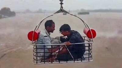 Two people being rescued by an Indian Coast Guard aircraft from a flood-hit area following heavy rainfall, at Devbhumi Dwarka district of Gujarat. (PTI)