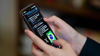 A Brazilian user of the social network X, formerly Twitter, browses posts on a cell phone in Brasilia on August 31, 2024. (EVARISTO SA/AFP) A Brazilian user of the social network X, formerly Twitter, browses posts on a cell phone in Brasilia on August 31, 2024. (EVARISTO SA/AFP)