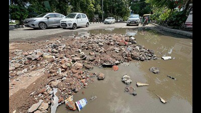 Commuters say potholes on the Lodhi Club Road hinder traffic, lead to frequent accidents. (Gurpreet Singh/HT)