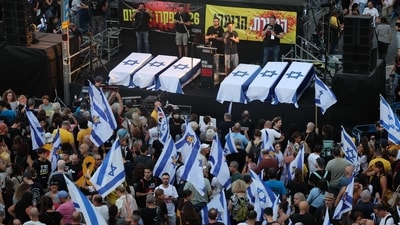 Thousands of protesters lift flags and placards around symbolic coffins representing six Israeli hostages whose bodies were recovered from the Gaza Strip, during an anti-government rally calling for the release of the captives held by Palestinian militants in Gaza since October, in Tel Aviv on September 1, 2024. Families of Israeli hostages have called for a nationwide general strike starting September 1 night to force the government to reach a deal to secure the release of captives still held in Gaza. (Photo by JACK GUEZ / AFP) (AFP) Thousands of protesters lift flags and placards around symbolic coffins representing six Israeli hostages whose bodies were recovered from the Gaza Strip, during an anti-government rally calling for the release of the captives held by Palestinian militants in Gaza since October, in Tel Aviv on September 1, 2024. Families of Israeli hostages have called for a nationwide general strike starting September 1 night to force the government to reach a deal to secure the release of captives still held in Gaza. (Photo by JACK GUEZ / AFP) (AFP)