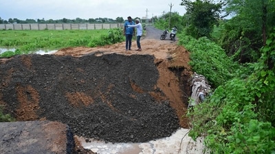 Onlookers inspect a road damaged by heavy rains on the outskirts of Ahmedabad (AFP) Onlookers inspect a road damaged by heavy rains on the outskirts of Ahmedabad (AFP)