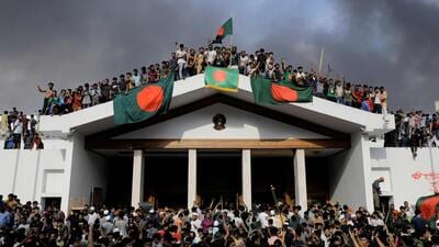 Anti-government protestors display Bangladesh's national flag as they storm Prime Minister Sheikh Hasina's palace in Dhaka on August 5. (AFP) Anti-government protestors display Bangladesh's national flag as they storm Prime Minister Sheikh Hasina's palace in Dhaka on August 5. (AFP)