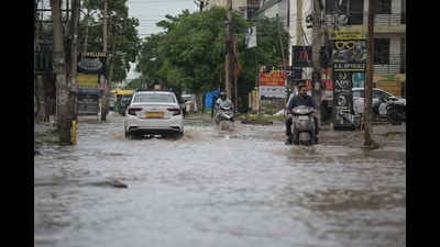 Commuters wade through a waterlogged road after rain in Mohali on Monday. (HT Photo) Commuters wade through a waterlogged road after rain in Mohali on Monday. (HT Photo)