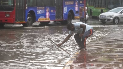 New Delhi, India - July 9, 2024: NDMC worker trying to open the choked drains on a water-logged street after heavy rains at Rafi Marg in New Delhi, India, on Tuesday, July 9, 2024. Heavy rains caused major waterlogging in many areas, leaving residents and commuters stranded, and causing a huge traffic gridlock. Waterlogging in many areas has led to divert bus routes. (Photo by Raj K Raj/ Hindustan Times) (Hindustan Times) New Delhi, India - July 9, 2024: NDMC worker trying to open the choked drains on a water-logged street after heavy rains at Rafi Marg in New Delhi, India, on Tuesday, July 9, 2024. Heavy rains caused major waterlogging in many areas, leaving residents and commuters stranded, and causing a huge traffic gridlock. Waterlogging in many areas has led to divert bus routes. (Photo by Raj K Raj/ Hindustan Times) (Hindustan Times)