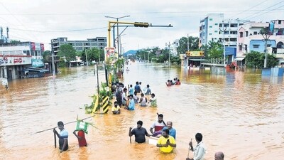 People wade through waterlogged roads in Vijayawada, Andhra Pradesh, on Monday. (Reuters)