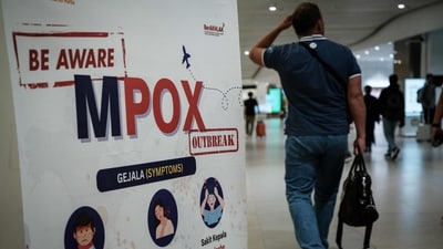 A passenger walks past a banner informing about Monkeypox (MPOX) at Soekarno-Hatta International Airport in Tangerang on August 26, 2024. (Photo by YASUYOSHI CHIBA / AFP) (AFP) A passenger walks past a banner informing about Monkeypox (MPOX) at Soekarno-Hatta International Airport in Tangerang on August 26, 2024. (Photo by YASUYOSHI CHIBA / AFP) (AFP)