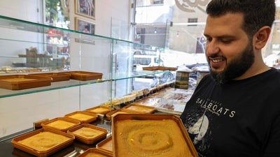 Samir Makari holds a tray of mufataka, a traditional Beiruti sweet, at his shop in the Lebanese capital. A kind of rice pudding made with turmeric, tahini sesame paste, sugar and pine nuts, mufataka is traditional in Beirut but less known even outside the city. (Photo by ANWAR AMRO / AFP) Samir Makari holds a tray of mufataka, a traditional Beiruti sweet, at his shop in the Lebanese capital. A kind of rice pudding made with turmeric, tahini sesame paste, sugar and pine nuts, mufataka is traditional in Beirut but less known even outside the city. (Photo by ANWAR AMRO / AFP)