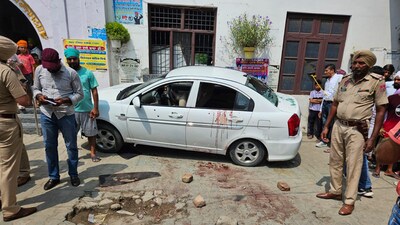 Police and forensic experts at the site where the car in which the siblings were travelling came under fire in Ferozepur on Tuesday. (HT Photo)