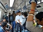 BJP MP Tejasvi Surya interacts with fellow passengers as he rides on a metro train in Bengaluru.