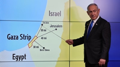 Israeli Prime Minister Benjamin Netanyahu stands before a map showing the Gaza Strip, during a press conference for the international media at the Government Press office in Jerusalem. ABIR SULTAN/Pool via REUTERS