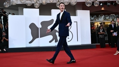 Actor Drew Starkey commanded attention on the red carpet in a three-piece navy blue suit, which included a fitted blazer, matching trousers, and a crisp white shirt. Complemented by shiny black shoes, he looked effortlessly dapper. (Photo by Marco BERTORELLO / AFP)