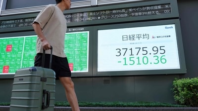 A man walks in front of an electronic quotation board displaying share prices on the Tokyo Stock Exchange in Tokyo. (AFP)