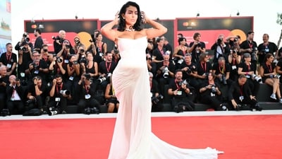 Georgina Rodriguez dazzled on the red carpet at the Venice Film Festival, donning a breathtaking white chiffon gown with an off-shoulder neckline and a floor-length hemline. (Photo by Alberto PIZZOLI / AFP)