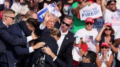 Republican presidential candidate and former U.S. President Donald Trump gestures with a bloodied face while he is assisted by U.S. Secret Service personnel after he was shot in the right ear during a campaign rally at the Butler Farm Show in Butler, Pennsylvania, U.S., July 13, 2024. (REUTERS)