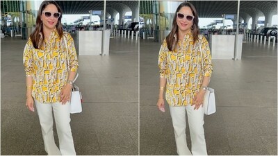 Madhuri Dixit's latest airport look is a perfect blend of comfort and style. She wore a yellow kurti with a collared neckline, paired with white pants for a chic yet effortless vibe. She accessorised her outfit with a white shoulder bag, a wristwatch, and a pair of chic sunglasses, making her travel look on point. (HT photo/VarinderChawla)