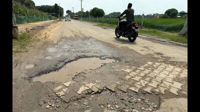 A commuter passing through a damaged road on PAU campus in Ludhiana on Thursday. (Gurpreet Singh/HT) A commuter passing through a damaged road on PAU campus in Ludhiana on Thursday. (Gurpreet Singh/HT)