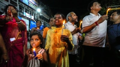 People including children with guardians hold candles as they protest against the rape and murder of a resident doctor at a government hospital in early August, in Kolkata. (AP) People including children with guardians hold candles as they protest against the rape and murder of a resident doctor at a government hospital in early August, in Kolkata. (AP)