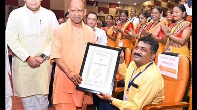 UP CM Yogi Adityanath came down from the stage to honour the injured teacher from Aligarh. (HT photo)
