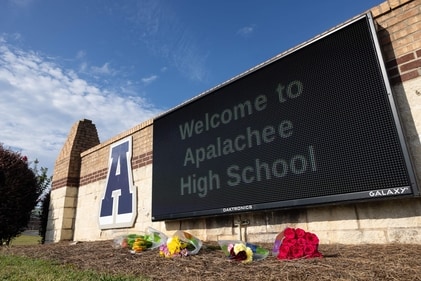 WINDER, GEORGIA - SEPTEMBER 5: Flowers lay in front of the school sign outside of Apalachee High School on September 5, 2024 in Winder, Georgia. Two students and two teachers were shot and killed at the school on September 4, and a 14-year-old suspect, who is a student at the school, is in custody. (Getty Images via AFP)