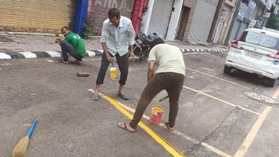 MCD workers mark parking lots under the new system. (HT Photo)