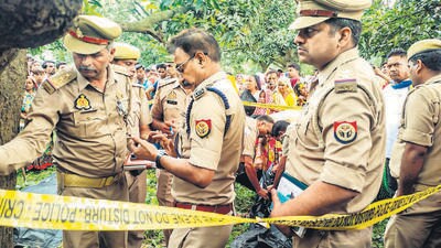 Police personnel investigate after the bodies of two girls were found hanging from a tree, at Kayamganj area in Farrukhabad, on August 27. (PTI) Police personnel investigate after the bodies of two girls were found hanging from a tree, at Kayamganj area in Farrukhabad, on August 27. (PTI)