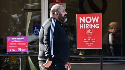 A pedestrian walks past a "Now Hiring" sign posted on a business storefront in San Gabriel, California on August 21, 2024. US job gains for the past twelve months ending in March showed there were 818,000 fewer jobs than previously reported in the largest downward revision since 2009. (AFP) A pedestrian walks past a "Now Hiring" sign posted on a business storefront in San Gabriel, California on August 21, 2024. US job gains for the past twelve months ending in March showed there were 818,000 fewer jobs than previously reported in the largest downward revision since 2009. (AFP)