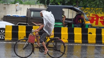 A commuter on a bicycle was seen using a polythene cover to avoid getting drenched during the rain on Friday morning in Gurugram. (Parveen Kumar/HT Photo) A commuter on a bicycle was seen using a polythene cover to avoid getting drenched during the rain on Friday morning in Gurugram. (Parveen Kumar/HT Photo)